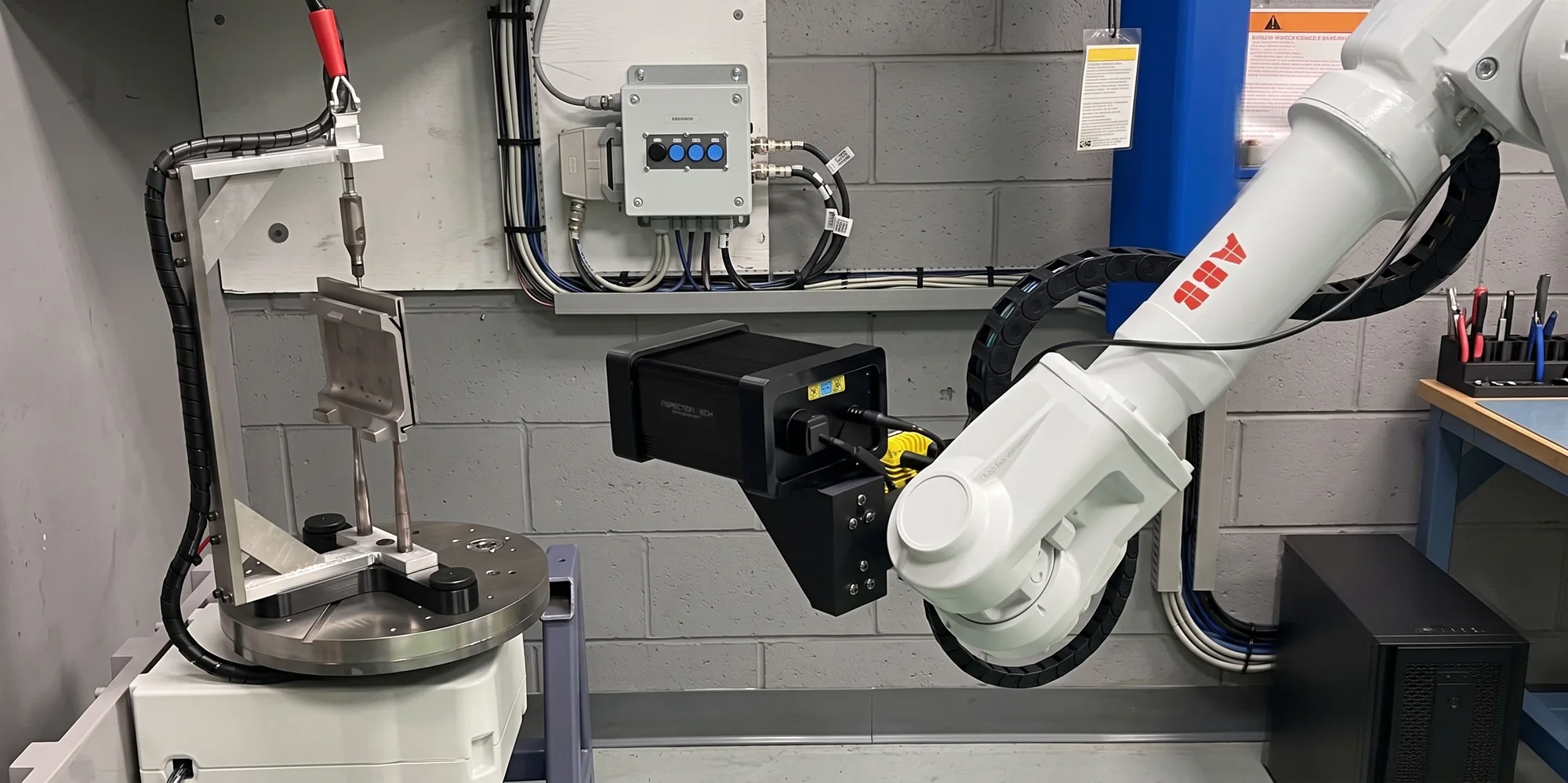 ML-3000 mounted on an ABB robot arm in a normally lit inspection cell